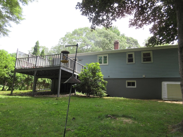 11 Ledgewood Dr, Ledyard, CT 06335 - back of property featuring a wooden deck, a chimney, and a lawn