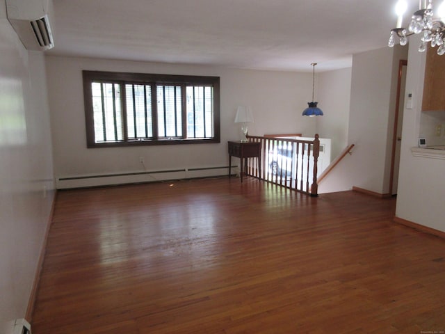 11 Ledgewood Dr, Ledyard, CT 06335 - unfurnished room featuring a wall mounted AC, wood finished floors, baseboard heating, and a chandelier