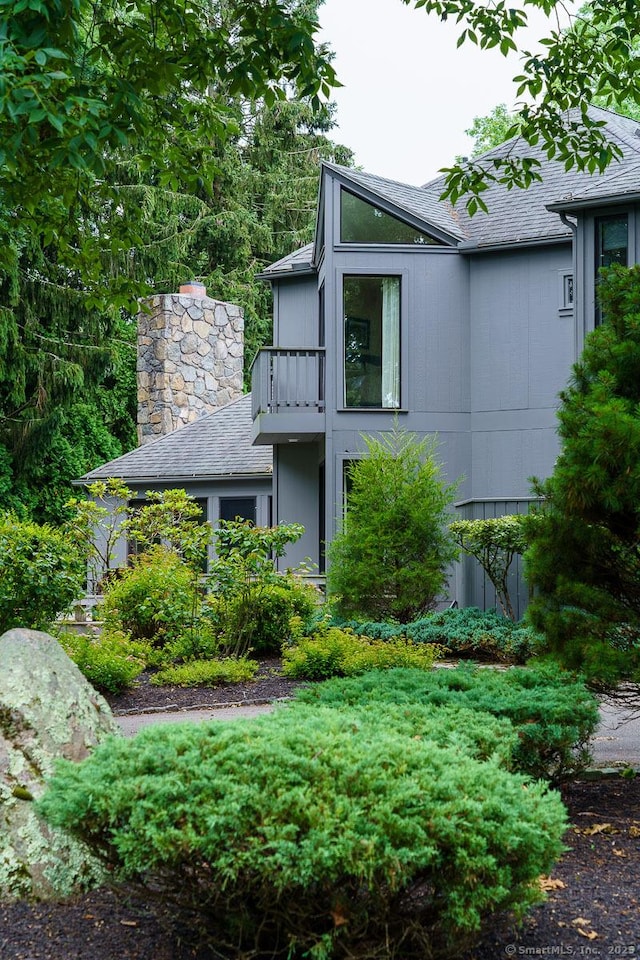 19 Money Point Rd, Stonington, CT 06355 - view of home's exterior featuring a balcony, roof with shingles, and a chimney