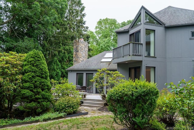 19 Money Point Rd, Stonington, CT 06355 - view of property exterior with a balcony, roof with shingles, a wooden deck, and a chimney