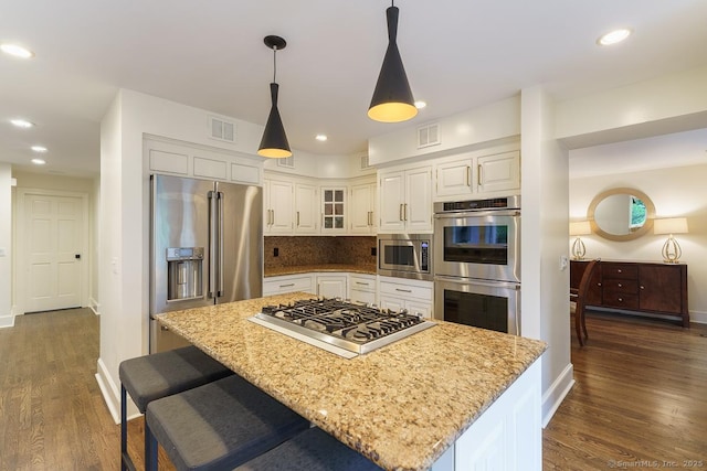 19 Money Point Rd, Stonington, CT 06355 - kitchen featuring appliances with stainless steel finishes, dark wood finished floors, white cabinetry, light stone counters, and tasteful backsplash