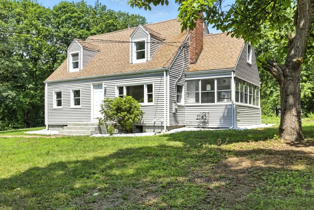 780 Park Ave, Windsor, CT 06095 - back of property with a chimney, roof with shingles, a lawn, and a sunroom