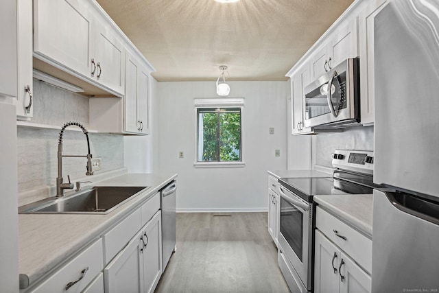 241 Heritage Vlg Unit C, Southbury, CT 06488 - kitchen with appliances with stainless steel finishes, decorative backsplash, light countertops, white cabinets, and a textured ceiling