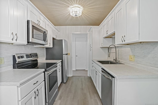 241 Heritage Vlg Unit C, Southbury, CT 06488 - kitchen with appliances with stainless steel finishes, white cabinets, light wood-style floors, light countertops, and backsplash