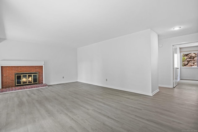 241 Heritage Vlg Unit C, Southbury, CT 06488 - unfurnished living room with wood finished floors and a brick fireplace
