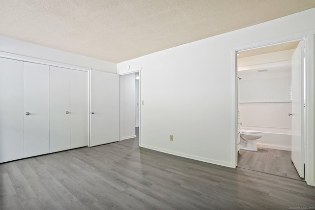 241 Heritage Vlg Unit C, Southbury, CT 06488 - unfurnished bedroom featuring wood finished floors, a closet, connected bathroom, and a textured ceiling
