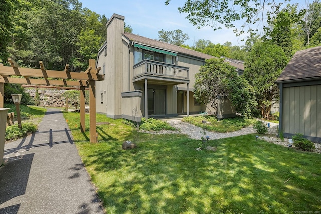 241 Heritage Vlg Unit C, Southbury, CT 06488 - rear view of house with a balcony, a yard, and a chimney
