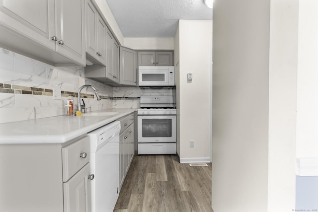 11 Bay Path Way Unit 11, Branford, CT 06405 - kitchen featuring white appliances, gray cabinets, light wood-type flooring, light countertops, and backsplash