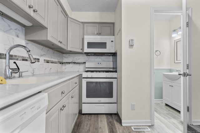 11 Bay Path Way Unit 11, Branford, CT 06405 - kitchen featuring white appliances, backsplash, light wood-type flooring, and light countertops