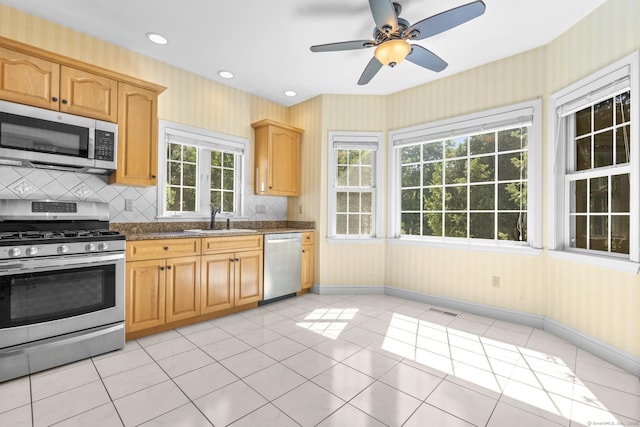 50 Middlebrooks Ave, Trumbull, CT 06611 - kitchen featuring appliances with stainless steel finishes, wallpapered walls, light tile patterned floors, backsplash, and a ceiling fan