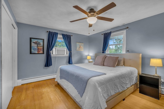 34 Fleming Ct, Groton, CT 06340 - bedroom featuring a baseboard radiator, multiple windows, and wood finished floors