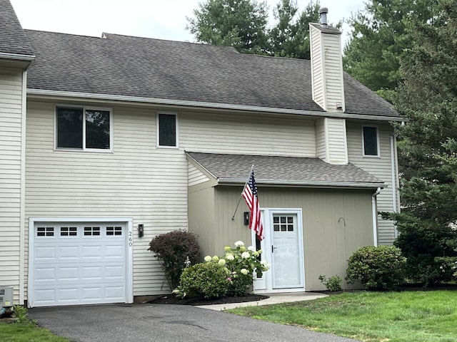 260 Alewife Ln Unit 260, Suffield, CT 06078 - back of house featuring a chimney, a garage, driveway, and a shingled roof