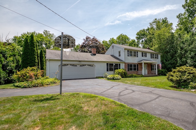198 N Timber Ln, Cheshire, CT 06410 - colonial-style house featuring an attached garage, asphalt driveway, a chimney, and a front lawn