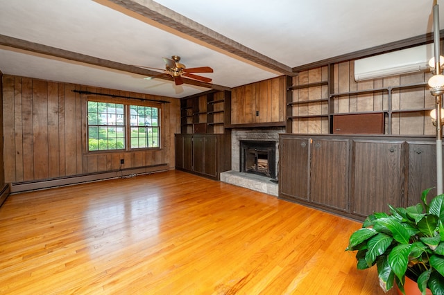 198 N Timber Ln, Cheshire, CT 06410 - unfurnished living room featuring beam ceiling, wooden walls, a wall mounted air conditioner, a ceiling fan, and light wood-style flooring