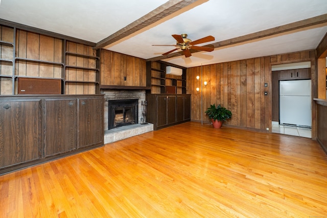 198 N Timber Ln, Cheshire, CT 06410 - unfurnished living room featuring beam ceiling, a wall mounted AC, a ceiling fan, light wood-type flooring, and wood walls