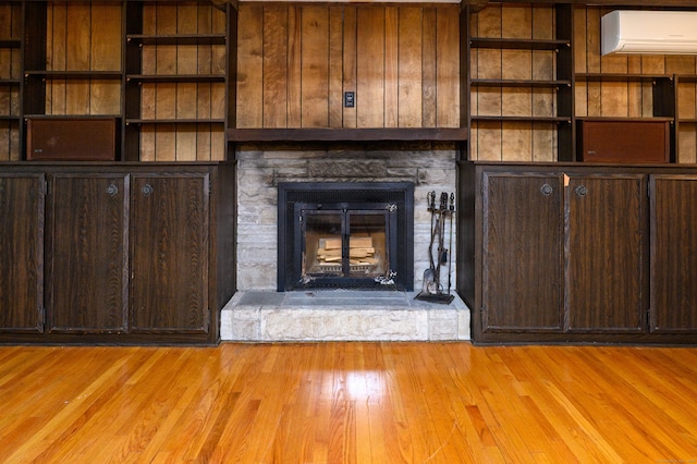 198 N Timber Ln, Cheshire, CT 06410 - unfurnished living room with a wall unit AC, light wood-style flooring, and a stone fireplace