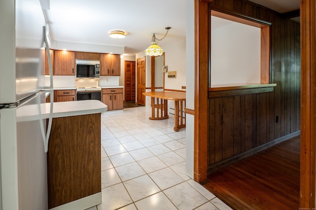 198 N Timber Ln, Cheshire, CT 06410 - kitchen featuring freestanding refrigerator, stainless steel microwave, electric range, light countertops, and wood walls