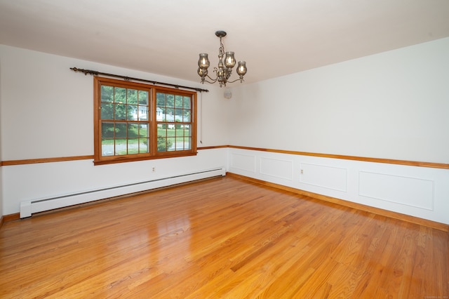 198 N Timber Ln, Cheshire, CT 06410 - spare room with baseboard heating, a chandelier, light wood-style flooring, and a wainscoted wall