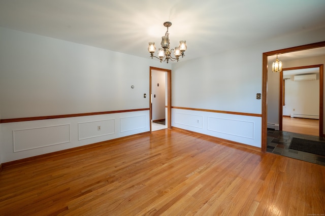 198 N Timber Ln, Cheshire, CT 06410 - spare room featuring a baseboard heating unit, a wall mounted AC, a chandelier, light wood-type flooring, and wainscoting