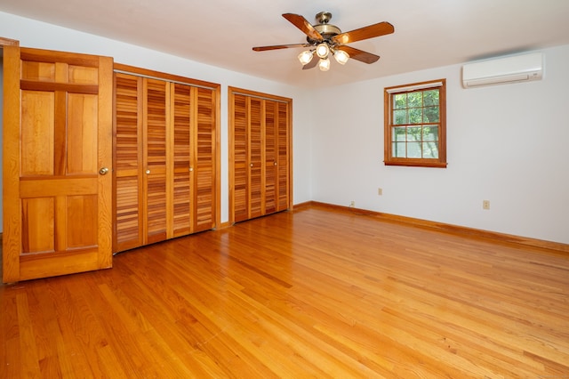 198 N Timber Ln, Cheshire, CT 06410 - unfurnished bedroom featuring a wall mounted AC, two closets, and light wood-type flooring