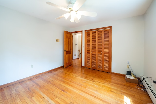 198 N Timber Ln, Cheshire, CT 06410 - unfurnished bedroom featuring a closet, light wood-type flooring, a baseboard radiator, and a ceiling fan