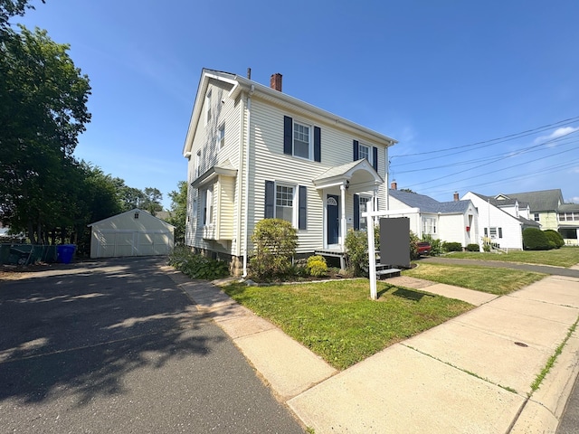 3 Mountain View Ave, Enfield, CT 06082 - view of front of home with a detached garage, a chimney, an outdoor structure, and a front yard