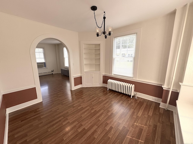 3 Mountain View Ave, Enfield, CT 06082 - unfurnished dining area featuring radiator, arched walkways, a chandelier, dark wood-type flooring, and built in shelves