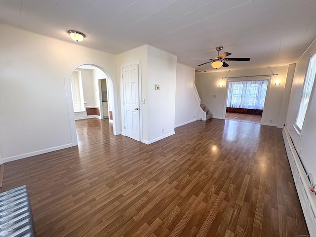 3 Mountain View Ave, Enfield, CT 06082 - unfurnished living room featuring a baseboard heating unit, dark wood-style floors, arched walkways, ceiling fan, and stairs