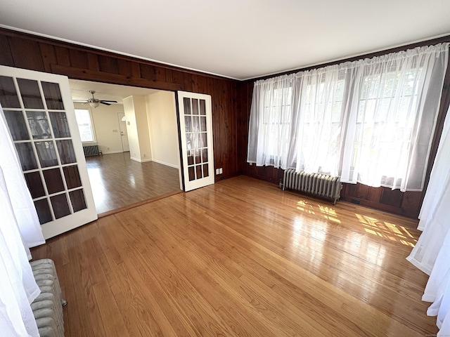 3 Mountain View Ave, Enfield, CT 06082 - spare room with radiator heating unit, wood walls, a ceiling fan, and wood finished floors
