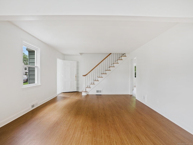 62 Severance Dr, Stamford, CT 06905 - unfurnished living room with wood finished floors and stairs