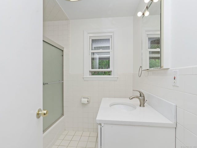 62 Severance Dr, Stamford, CT 06905 - full bathroom with tile walls, vanity, healthy amount of natural light, combined bath / shower with glass door, and wainscoting