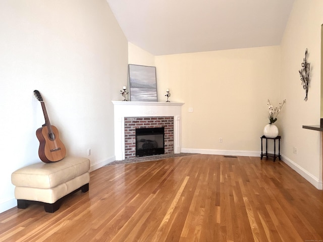 41 Calloway Dr, Milford, CT 06461 - unfurnished living room with lofted ceiling, light wood-style floors, and a brick fireplace