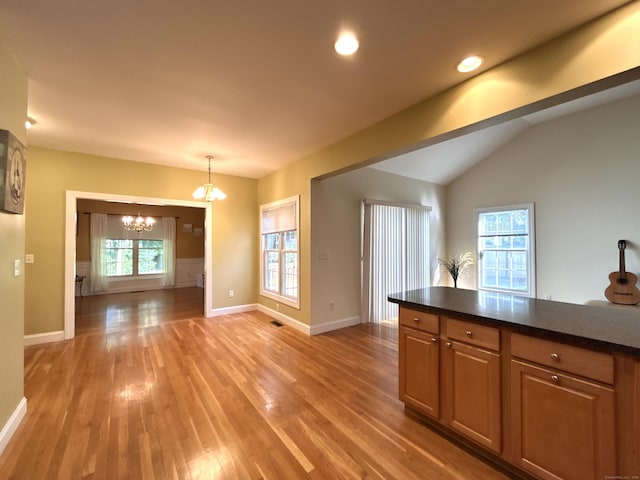 41 Calloway Dr, Milford, CT 06461 - kitchen featuring a chandelier, light wood-type flooring, dark countertops, lofted ceiling, and pendant lighting