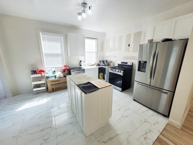 21 Arch St, Waterbury, CT 06710 - kitchen featuring stainless steel appliances, light marble finish flooring, white cabinets, a kitchen island, and light countertops