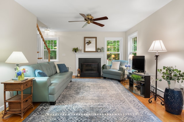 15 Tisbury Rd, Old Lyme, CT 06371 - living area with healthy amount of natural light, ceiling fan, wood finished floors, and baseboard heating