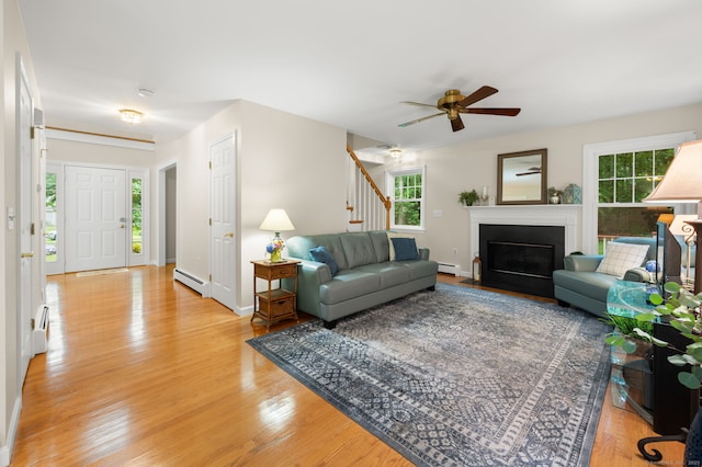 15 Tisbury Rd, Old Lyme, CT 06371 - living area with a baseboard heating unit, light wood finished floors, plenty of natural light, and ceiling fan