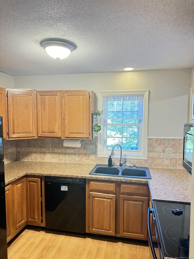 4 Starrwood Dr Unit 4, Norwich, CT 06360 - kitchen with black appliances, a textured ceiling, light wood-style flooring, light countertops, and backsplash