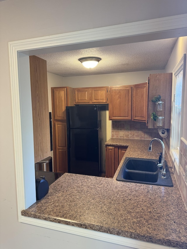 4 Starrwood Dr Unit 4, Norwich, CT 06360 - kitchen featuring freestanding refrigerator, dark countertops, brown cabinetry, and a peninsula