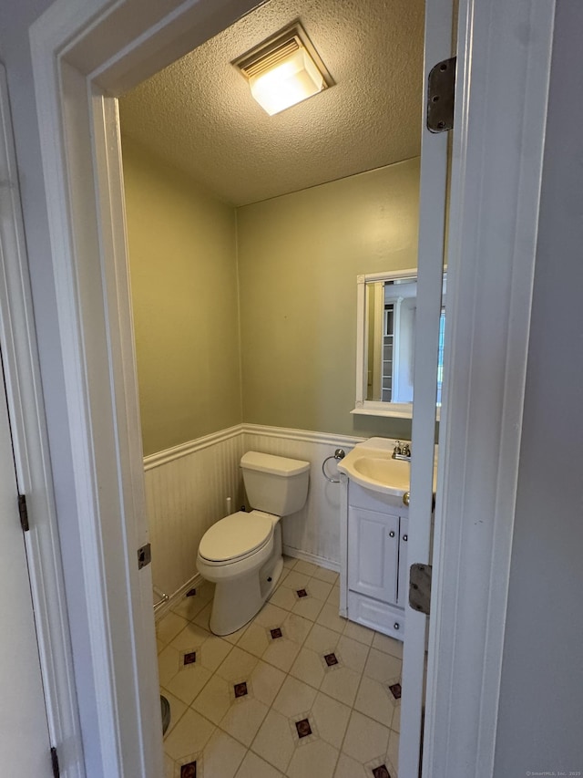 4 Starrwood Dr Unit 4, Norwich, CT 06360 - bathroom with a wainscoted wall, tile patterned flooring, vanity, and a textured ceiling
