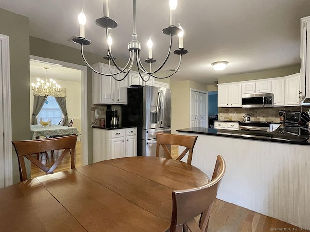 1040 Purchase Brook Rd, Southbury, CT 06488 - kitchen featuring stainless steel appliances, a chandelier, dark countertops, tasteful backsplash, and white cabinets