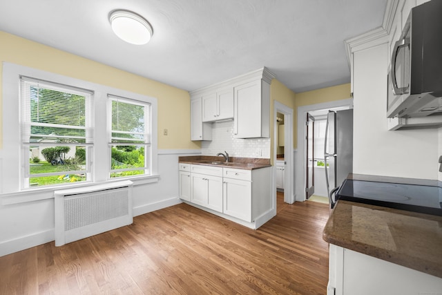47 Park Ave, Enfield, CT 06002 - kitchen featuring stainless steel appliances, radiator, light wood-style flooring, and dark countertops