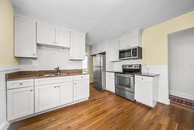 47 Park Ave, Enfield, CT 06002 - kitchen with appliances with stainless steel finishes, dark countertops, tasteful backsplash, dark wood-type flooring, and white cabinetry
