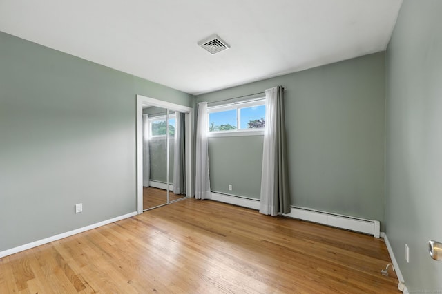24 Westerly Dr, Enfield, CT 06082 - unfurnished bedroom featuring baseboard heating and wood finished floors