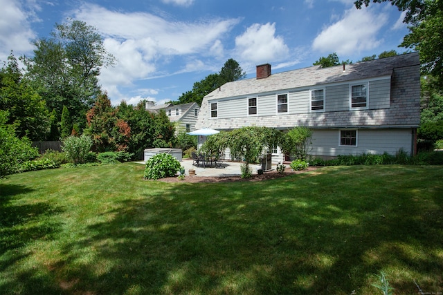 23 Mountain View Dr, West Hartford, CT 06117 - back of property with a patio, a lawn, and a chimney