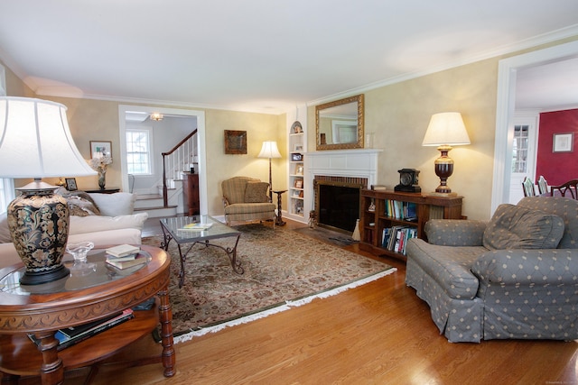 23 Mountain View Dr, West Hartford, CT 06117 - living area with wood finished floors, stairs, crown molding, and a fireplace