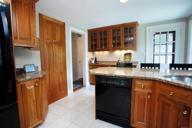 23 Mountain View Dr, West Hartford, CT 06117 - kitchen featuring black appliances, brown cabinetry, light stone countertops, glass insert cabinets, and light tile patterned floors