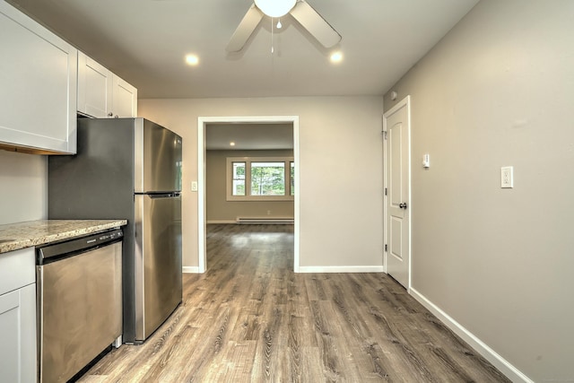 56 Wakelee Avenue Ext Unit 12, Shelton, CT 06484 - kitchen with appliances with stainless steel finishes, a baseboard radiator, wood finished floors, a ceiling fan, and white cabinets