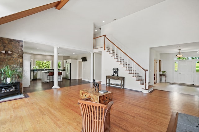 168 Sunset Hill Rd, Redding, CT 06896 - living room featuring a high ceiling, stairs, wood finished floors, decorative columns, and beam ceiling