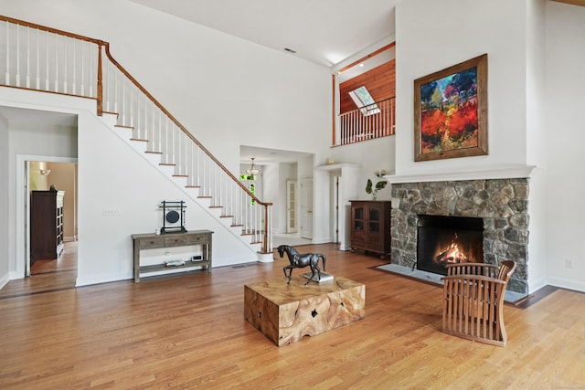 168 Sunset Hill Rd, Redding, CT 06896 - living room with a towering ceiling, wood finished floors, stairway, a fireplace, and a chandelier