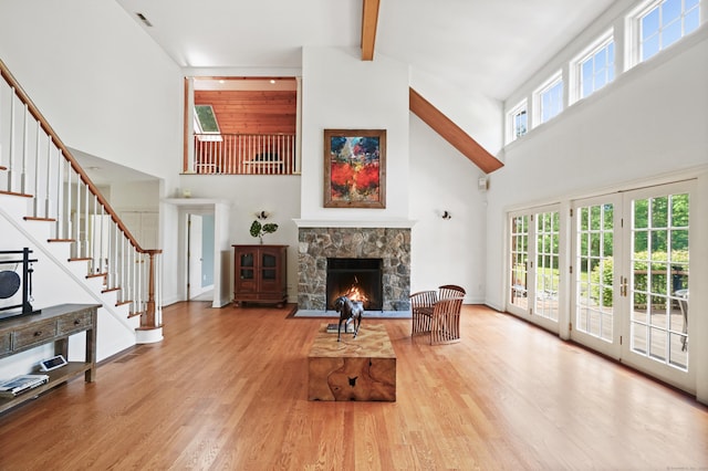 168 Sunset Hill Rd, Redding, CT 06896 - living room featuring high vaulted ceiling, stairs, beam ceiling, a fireplace, and wood finished floors